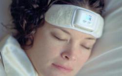 Woman reducing teeth grinding and preventing migraines by using biofeedback headband in sleep